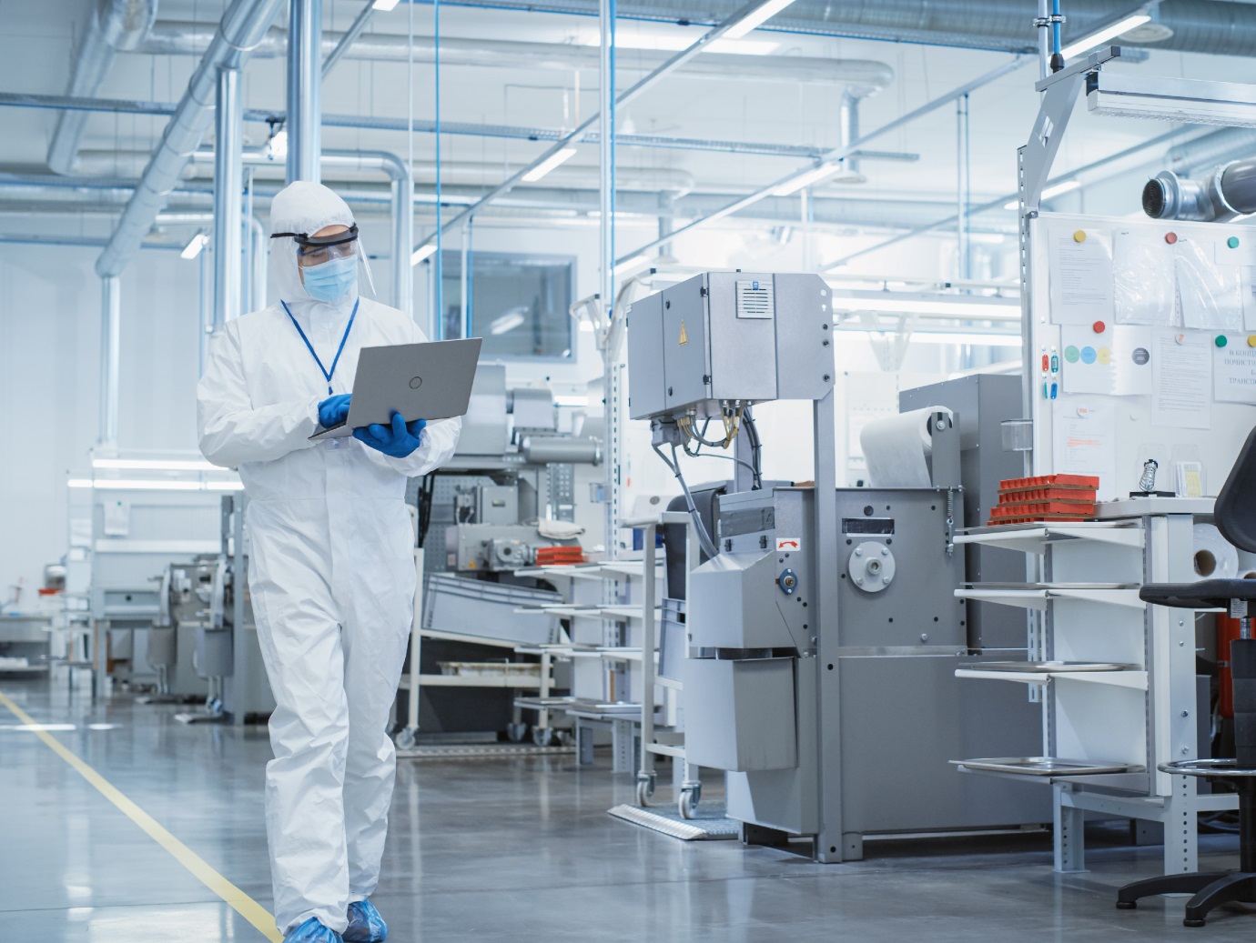 A scientist using laptop in a manufacturing facility